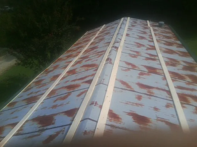 Rusted metal roof panels with new wood purlins before replacement — Storm Damage Roof Repair in Altmar by Roofing Brothers