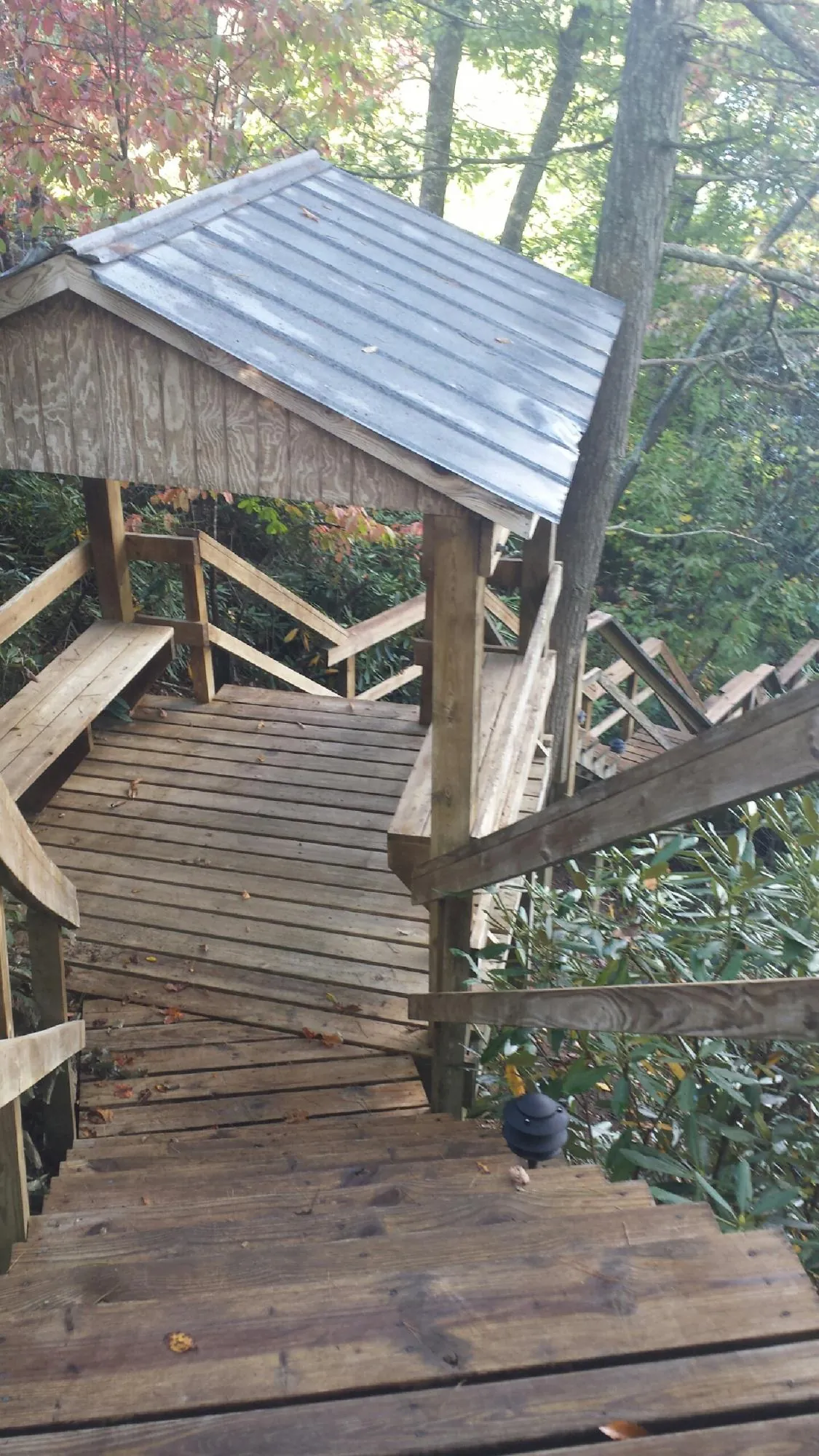 Metal roofed shelter over wooden steps on a wooded walkway — Skylight Repair & Installation work by our crew in Altmar
