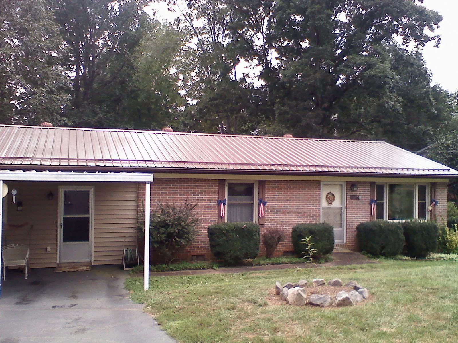 Bronze metal roof and carport on a brick ranch home — Roof Repair work by our crew in Altmar